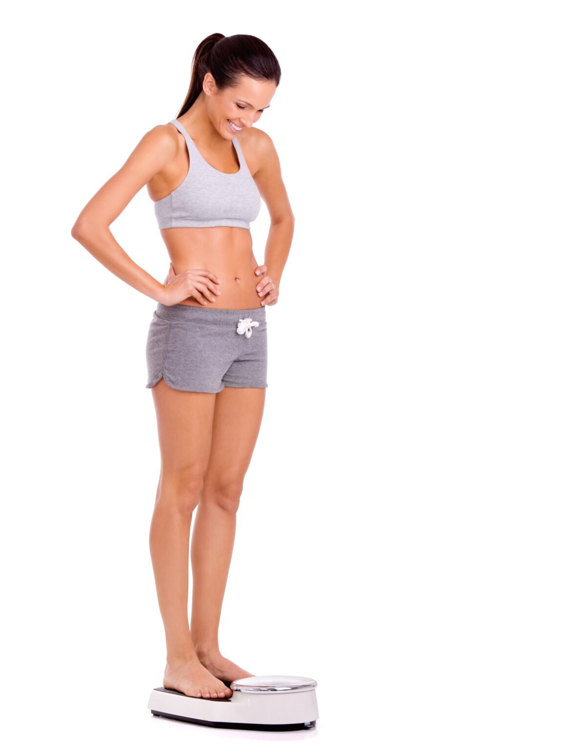 Smiling woman checking her progress on a scale during a medical weight loss programme