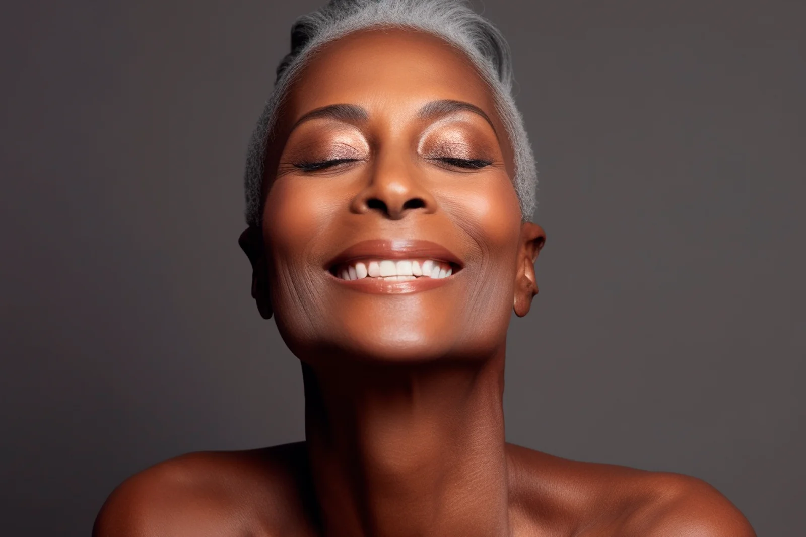 Mujer de piel oscura sonriendo, representando tratamientos de rejuvenecimiento y anti-aging para la piel.